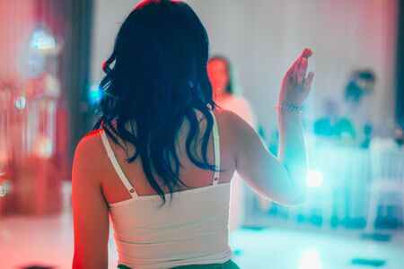 woman dancing in night club from the backの写真素材