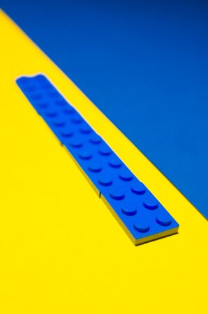yellow and blue toy bricks for kids. Playing in plastic pieces and elements of constructor conceptの写真素材