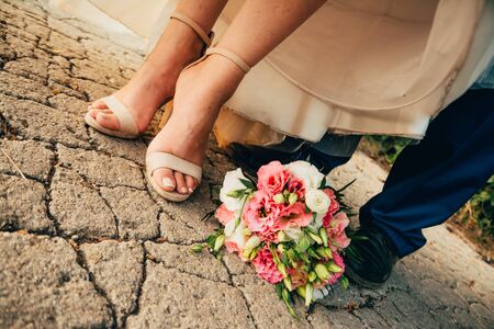 bride and groom shoes with flower bouquetの写真素材
