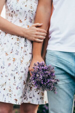bunch of lavender flowers in hands of young coupleの写真素材