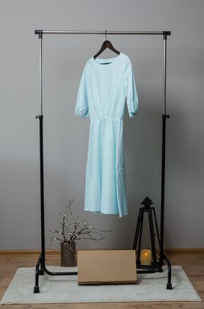 light blue long dress on hanger on garment rack in fashion design studio with mockup box for writing your brandの写真素材