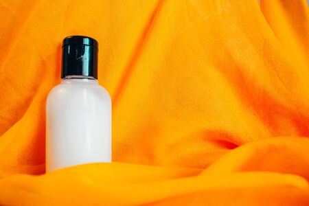 body lotion in travel bottle on orange backgroundの写真素材