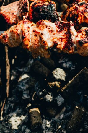 close up view of shish kebab on skewers on brazier with coalsの写真素材