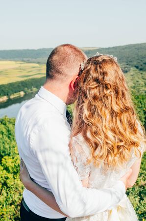 a couple on the top hill with wide landscape view on a riverの写真素材