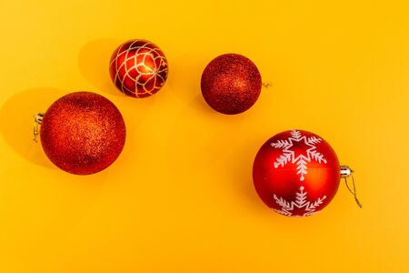 red christmas tree balls isolated on yellow background. choose the color for decorating your christmas tree with toysの写真素材