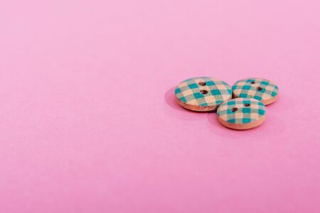 blue cute buttons isolated on pink backgroundの写真素材