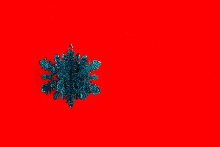 sparkling blue snowflake toy on isolated red background from top viewの写真素材