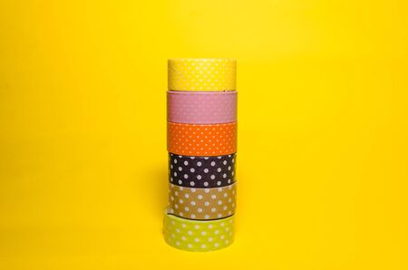 background of colorful washi tapes in a line isolated on yellow backgroundの写真素材