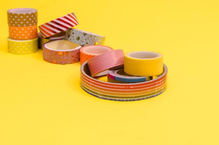 background of colorful washi tapes isolated on yellow backgroundの写真素材