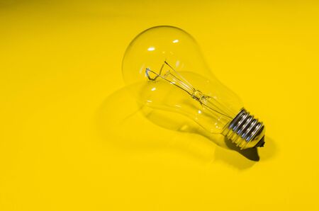 glass light bulb isolted on yellow background. new idea conceptの写真素材