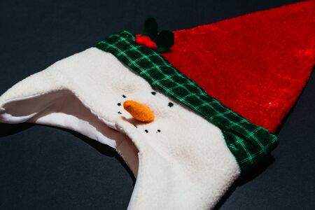 christmas hat with snowman isolated on black background. christmas unique and thematic clothesの写真素材