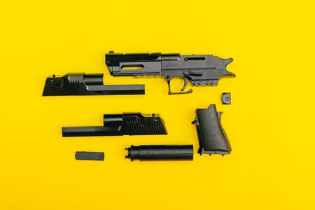 mans hands assembling toy handgun from the parts from top view. planned murder conceptの写真素材