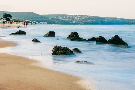 wide view of sand sea beach with big rocksの写真素材