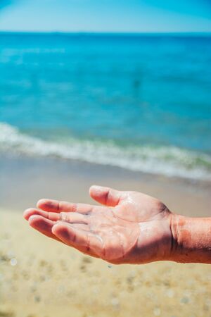 small transpatent jellyfish in tha hand on the sand beachの写真素材