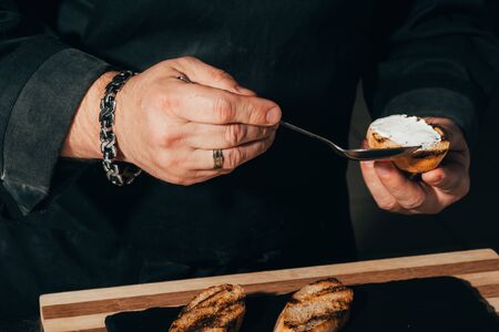 chef cooker smears toast with cream cheeseの写真素材