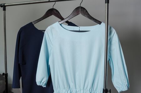 close up of two dresses on hanger on garment rack in fashion design studio with mockup box for writing your brandの写真素材