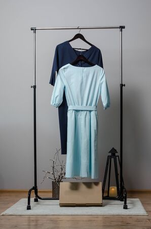 dresses on hanger on garment rack in fashion design studio with mockup box for writing your brandの写真素材