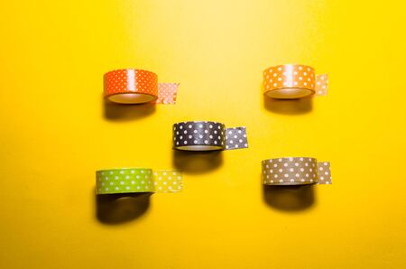 colorful washi tapes isolated on yellow background. top view. flat lay. Feminine stationeryの写真素材