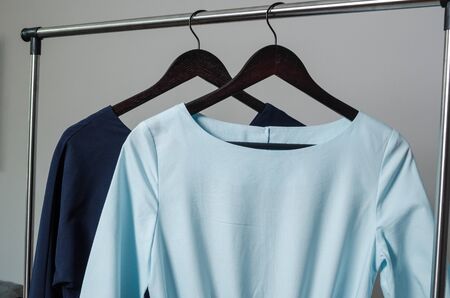close up of two dresses on hanger on garment rack in fashion design studio with mockup box for writing your brandの写真素材