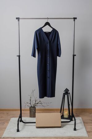 New red dress on hanger on garment rack in fashion design studio with mock up box for writing your brandの写真素材