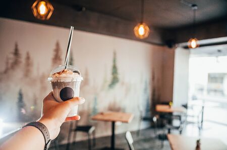 milk shake in hand of buyer . cooling drinks in local coffee shopの写真素材