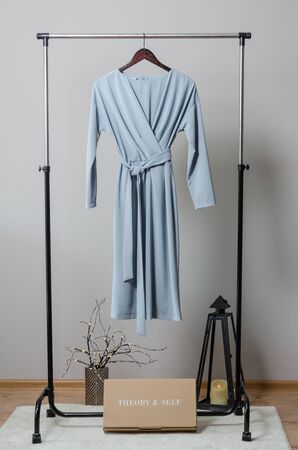 light blue long dress on hanger on garment rack in fashion design studio with mockup box for writing your brandの写真素材