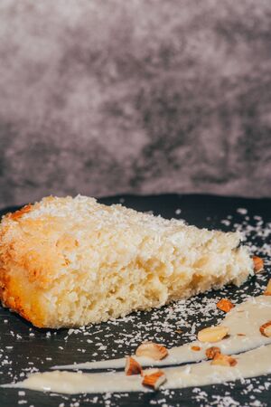 a piece of cake with almonds and coconut shvings on top