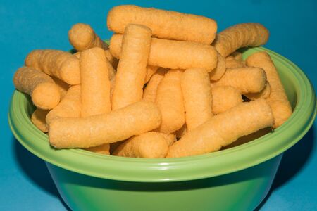 puff cheese corn snacks in a bowlの写真素材