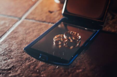 wedding gold rings on a mirror on a wedding dayの写真素材