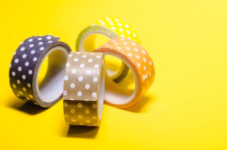 background of colorful washi tapes isolated on yellow backgroundの写真素材