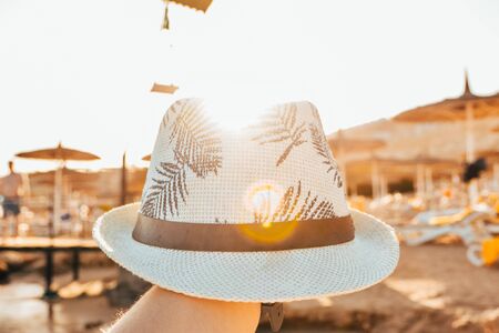 male panama hat with palm leaves and sunny beachの写真素材