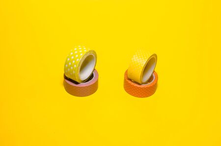 colorful dotted washi tapes isolated on yellow background from top viewの写真素材