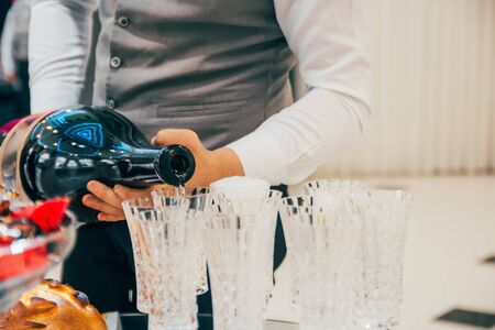 waiter pours champagne into wine glasses on the weddingの写真素材