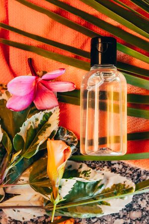 transparent hotel bath tube with exotic flowers . travel bottle set mock upの写真素材