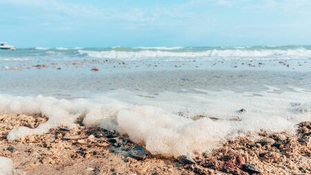foam from the sea on the sand beachの写真素材