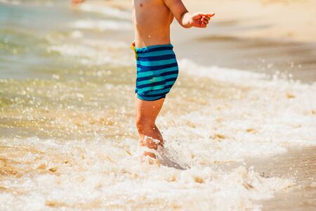 boy watching waves at the sea beach. children on summer vacationの写真素材