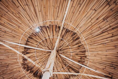 yellow straw umbrella from a lower angle  .の写真素材