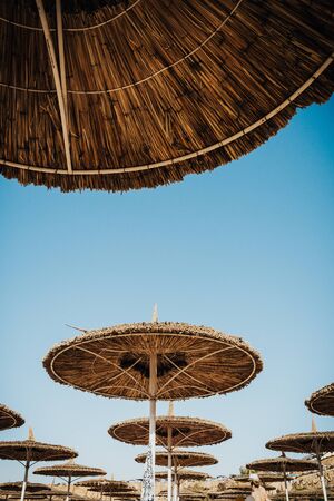 group of straw umbrellas from a lower angle  on sand beach of Egypt .の写真素材