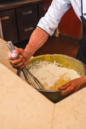 cooker in uniform kneading the dough with a whiskの写真素材