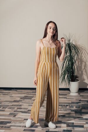 girl in yellow woman overalls with white stripes posesの写真素材