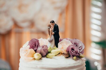 figurines of the bride and groom kissing on a wedding cakeの写真素材