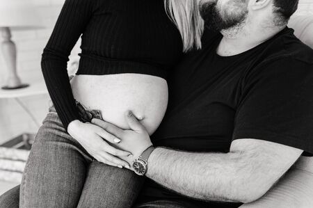 man holds his hand on the abdomen  of a pregnant wife. happy young family concept.の写真素材