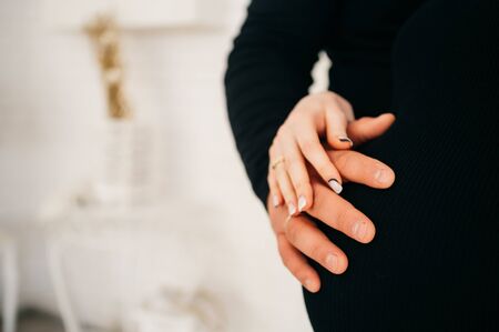 man holds his hand on the abdomen  of a pregnant wife. happy young family concept.の写真素材