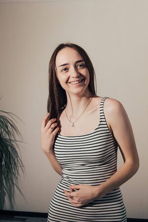 laughting girl in a white dress with black stripesの写真素材