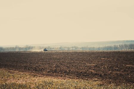 Tractor plows a field in the spring accompanied by rooks tractor .の写真素材