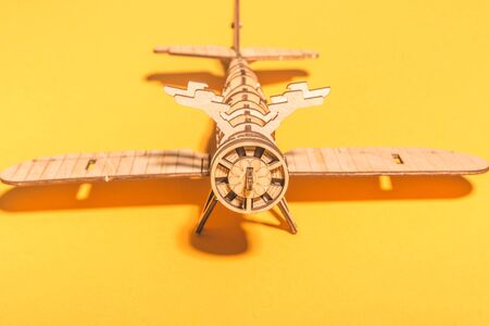 assembled wooden airplane constructor on a yellow background . children spend useful time concept .