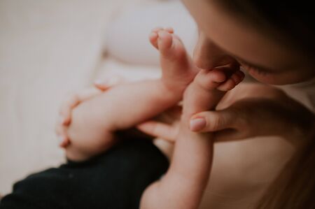 mother kisses the feet of her newborn baby. tenderness and motherly love concept. selective focus .の写真素材