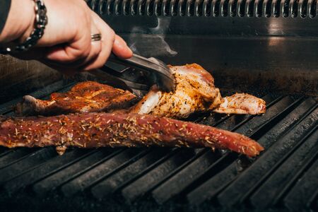fried meat on  grill . chef  cooking tasty steaks with fire   .の写真素材