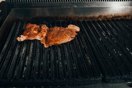 raw meat on  grill .  tasty steaks on old barbecue .の写真素材