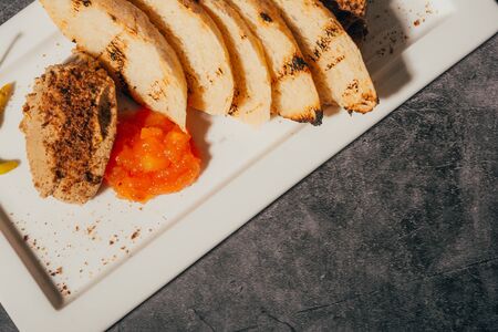 pate with fried slices of bread and jam , restaurant menu . close up .